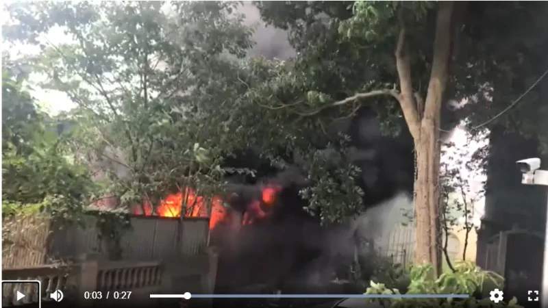 Thick black smoke billowing from a scrap yard blaze near high-rise residential buildings