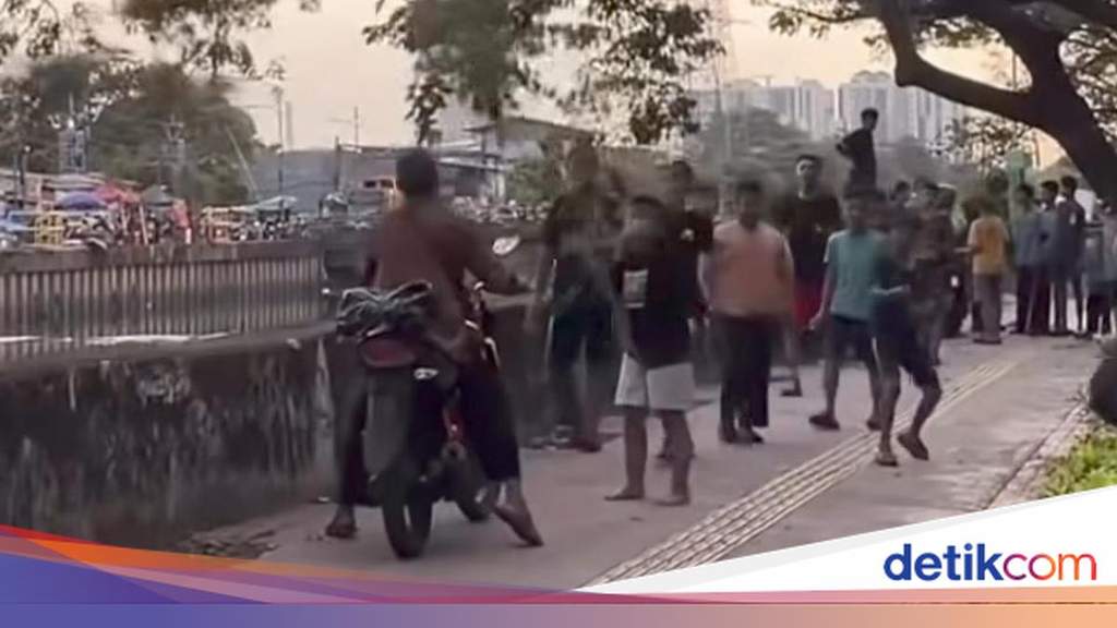 Children Stop Motorcyclists on West Jakarta Sidewalk