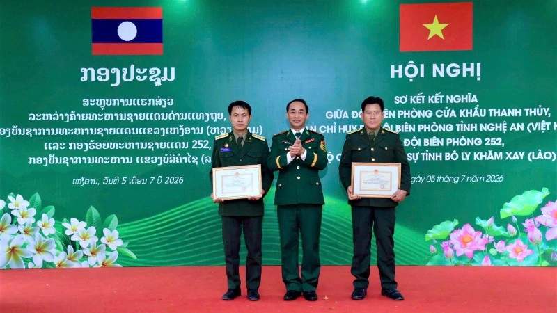 Military officials from Vietnam and Laos reviewing joint border defense strategies at a conference.