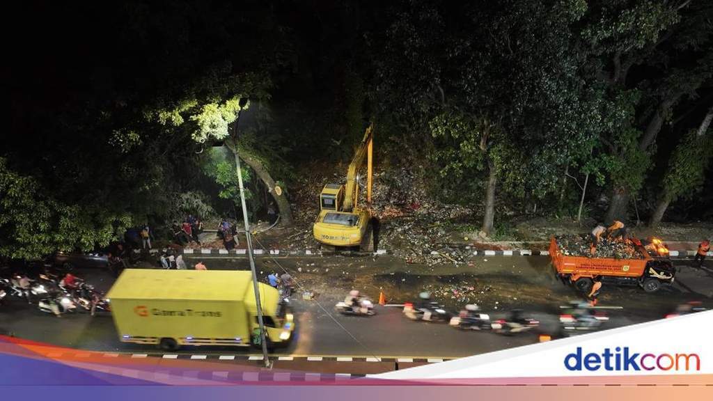 Workers clearing a massive accumulation of garbage blocking the Kali Baru river in Bogor