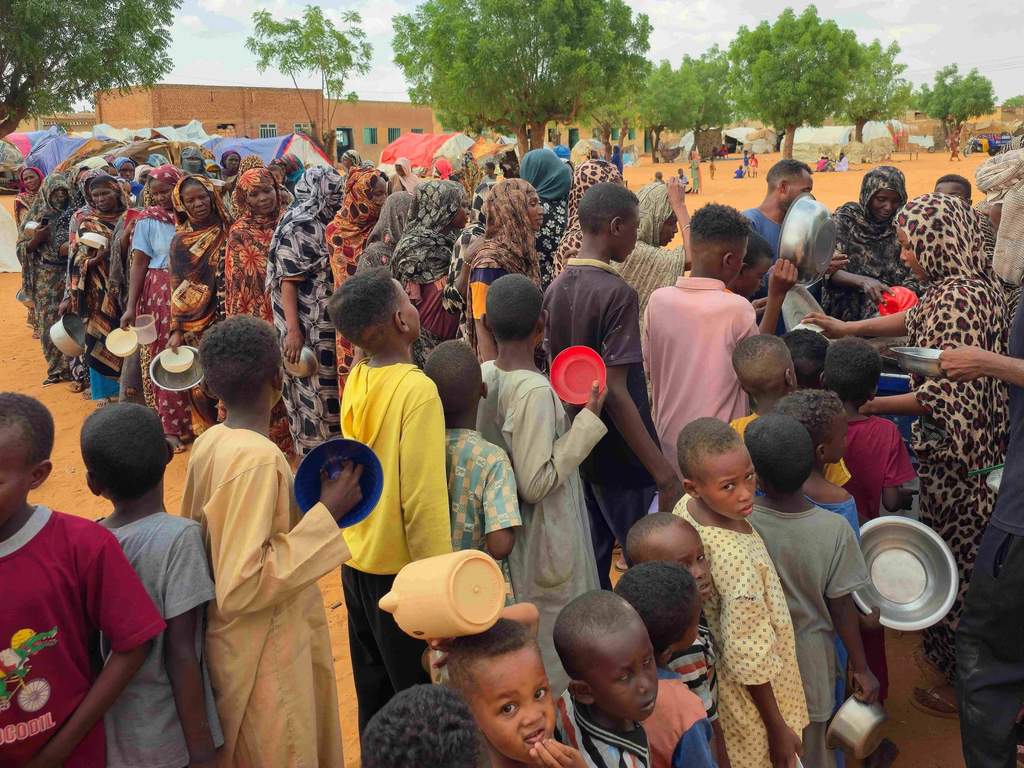 Displaced families seeking temporary shelter in conflict-torn Sudan.