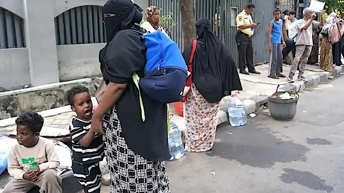 Foreign refugees set up makeshift tents on a Jakarta sidewalk.