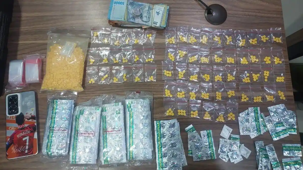 Evidence of seized prescription pills and cash displayed by police.