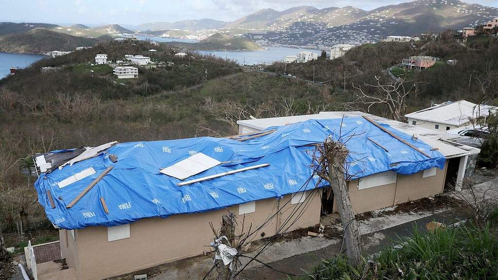 Blue FEMA tarp covering damaged roof after hurricane strike